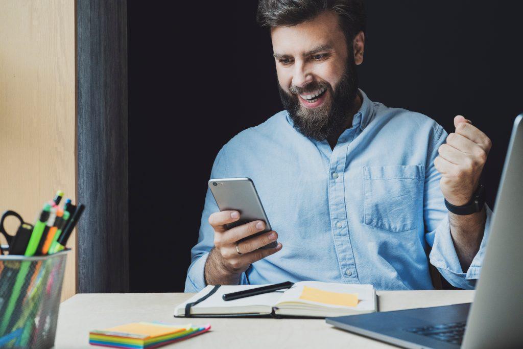 man smiling at phone getting paid